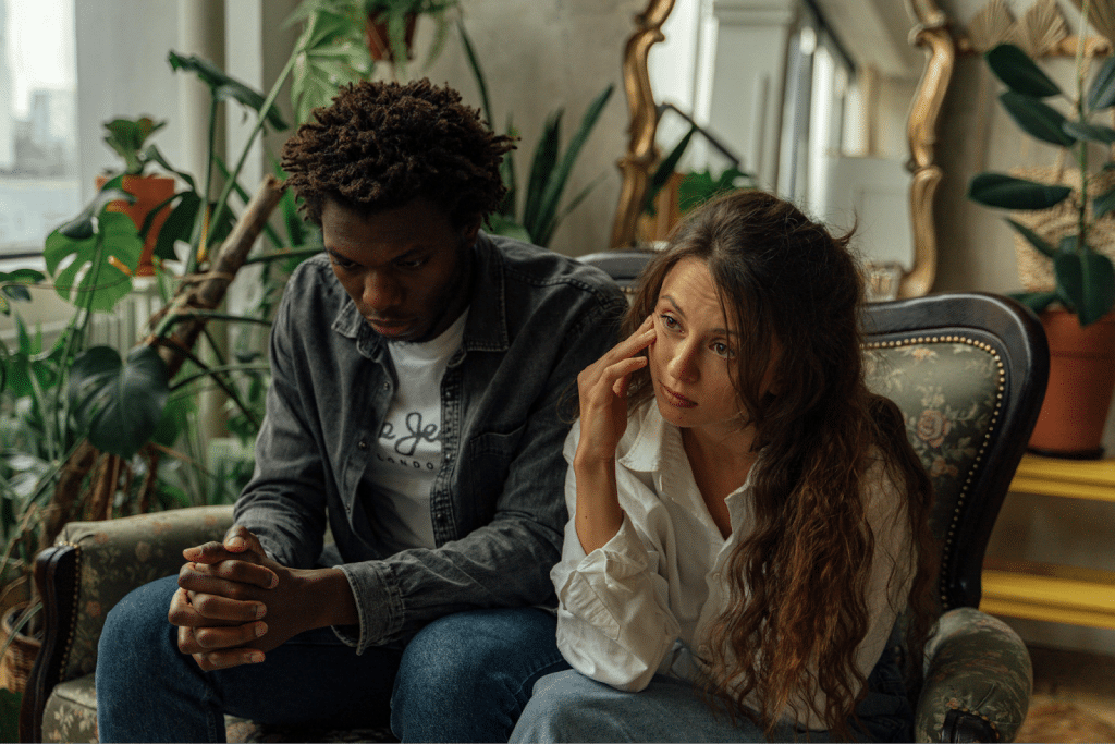Unhappy Couple Sitting Next to Each Other on a Couch