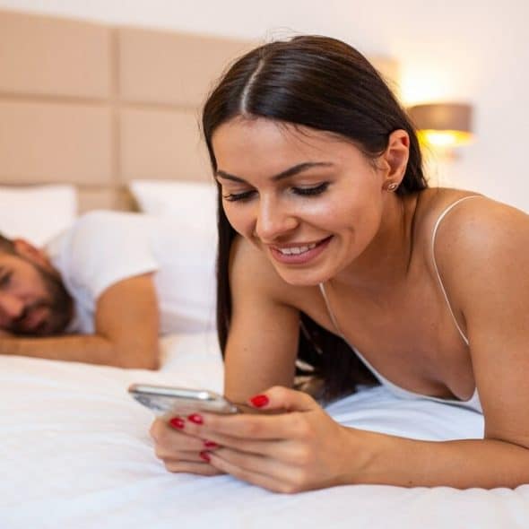 A man looking at his girl texting