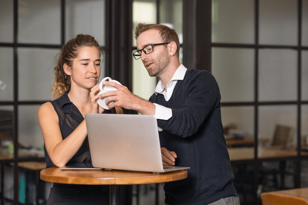 Business partners chatting and working at cafe table