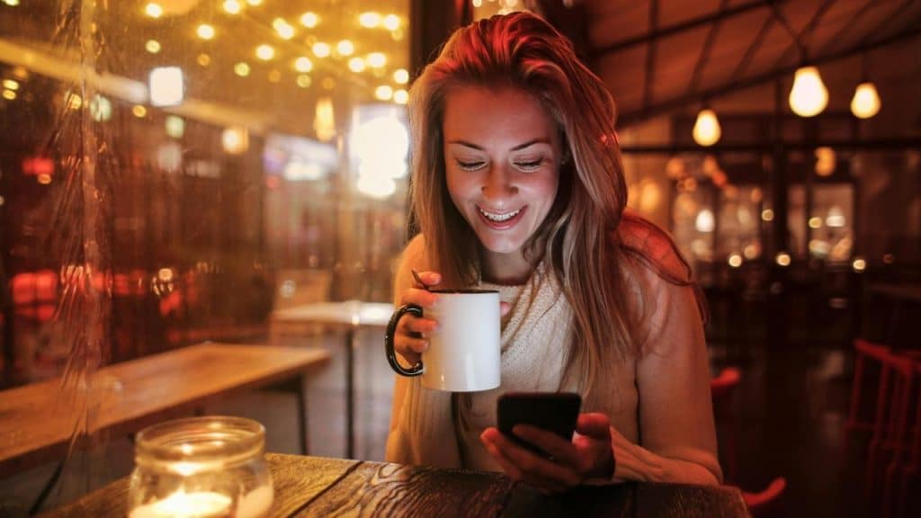 A smiling woman holding a mug