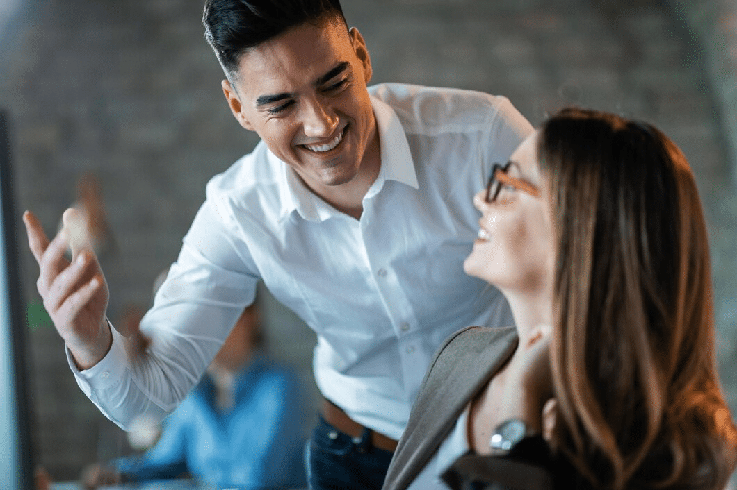 Man and woman talking and smiling at work