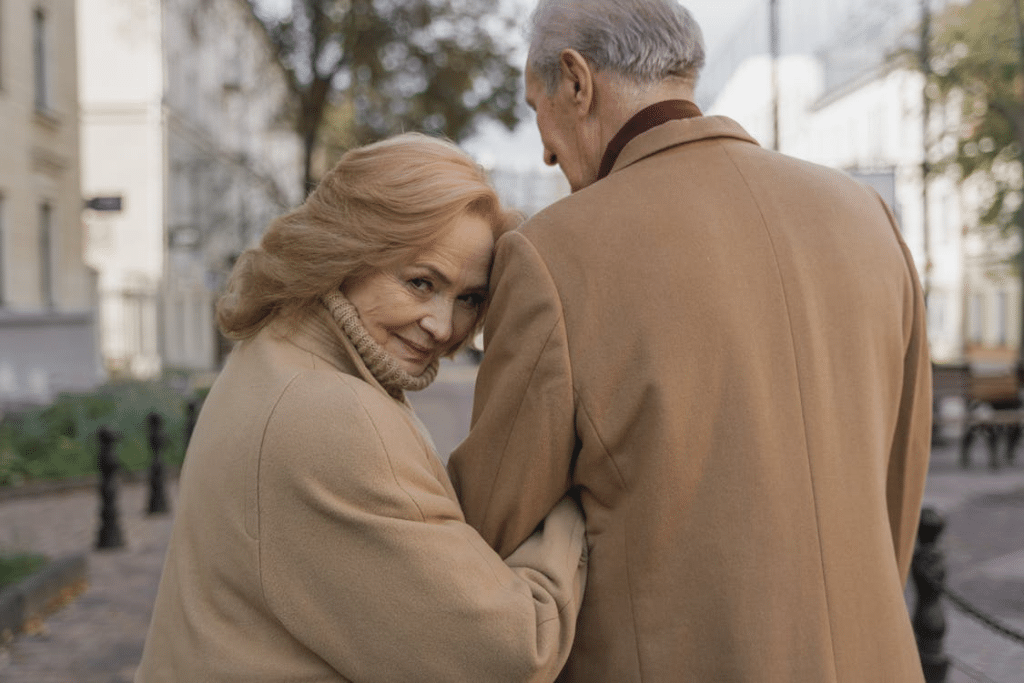 Senior couple walking down the street, happy woman looking back