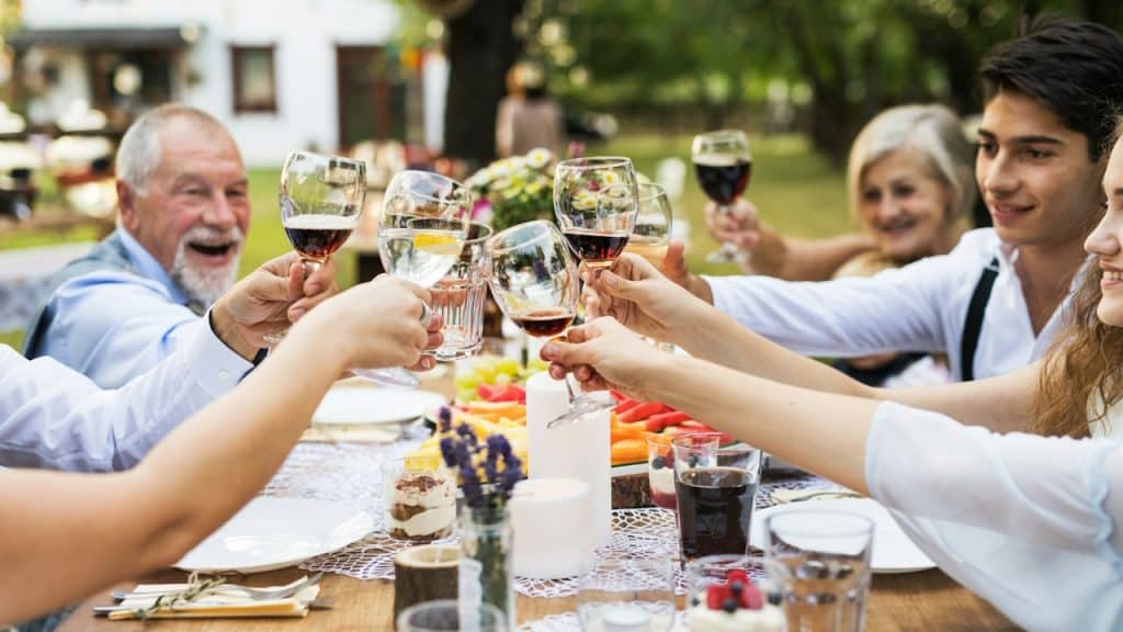 A family sitting at a dinner table and having a toast.