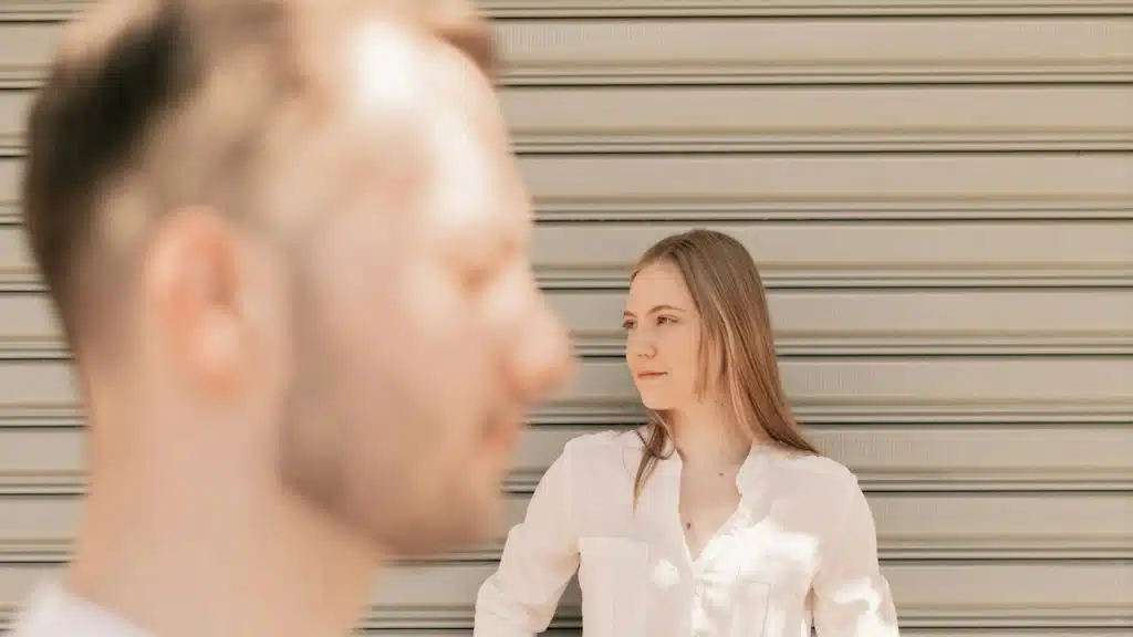 A man and a woman standing in front of a garage door.