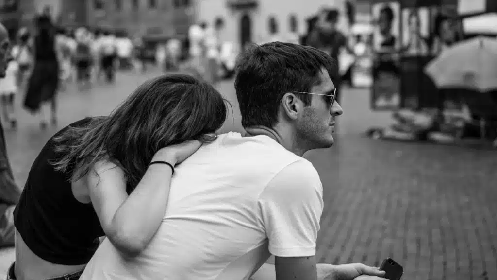 A man and a woman sitting on a bench.