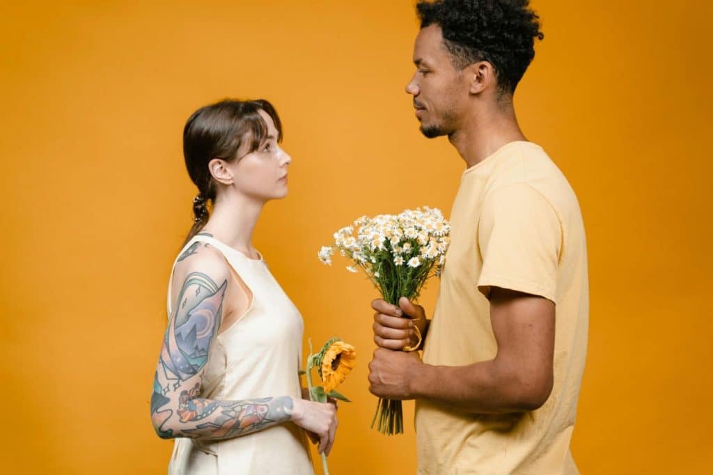 A man giving flower to woman