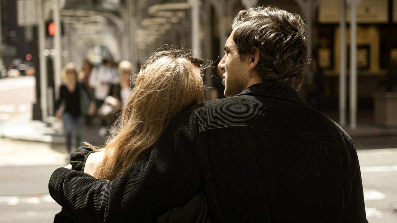 A couple walking together with their arms around each other