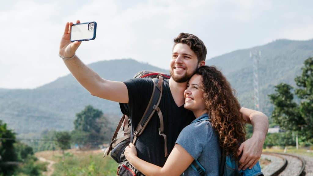A couple taking a selfie while hiking outdoors.