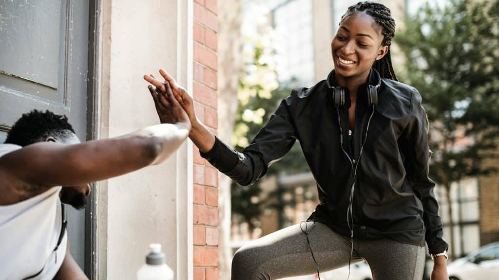 Fitness partner giving high five to each other.