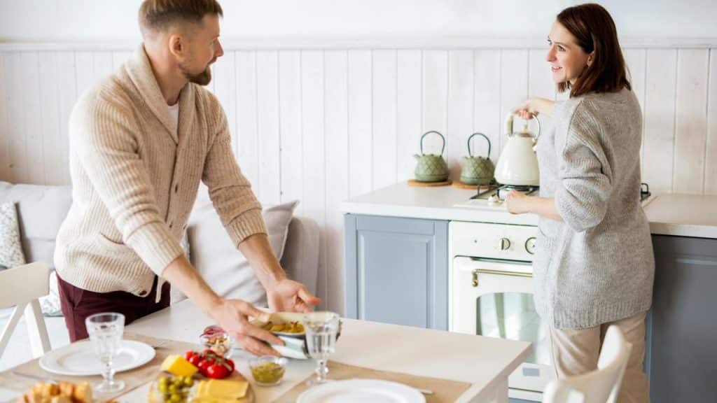 A couple preparing food together in a bright kitchen.