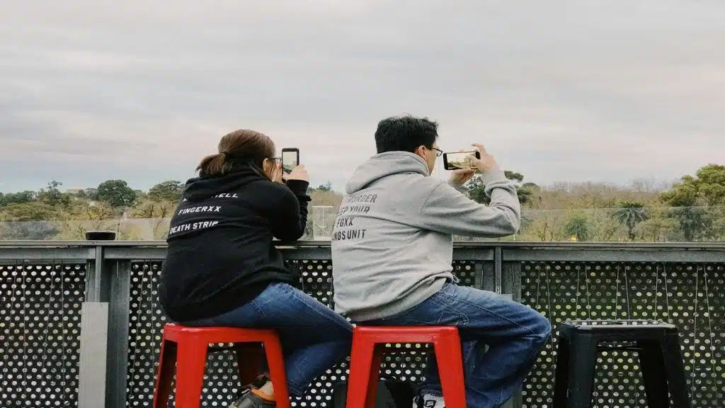 couple sitting together using phones