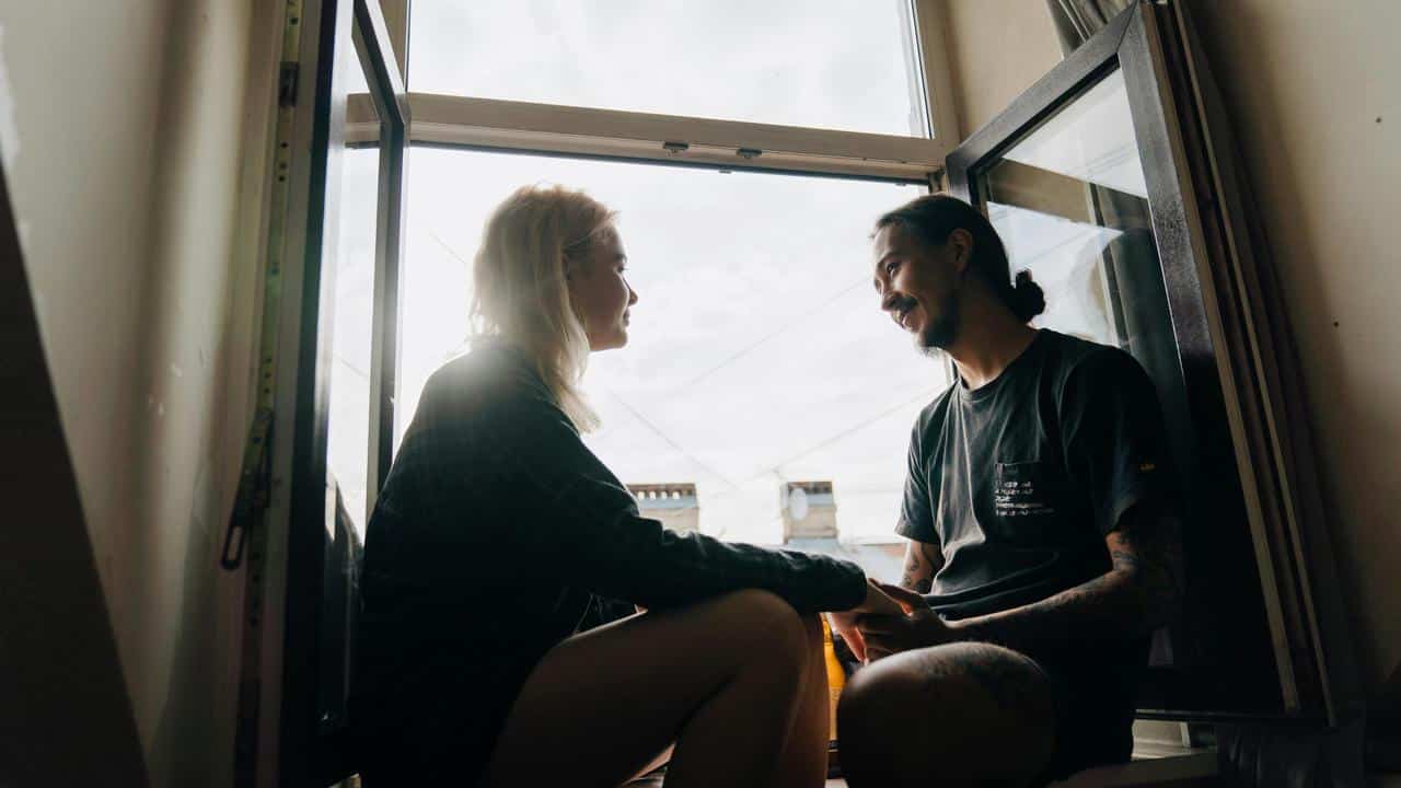 A pair of people sitting in an open window