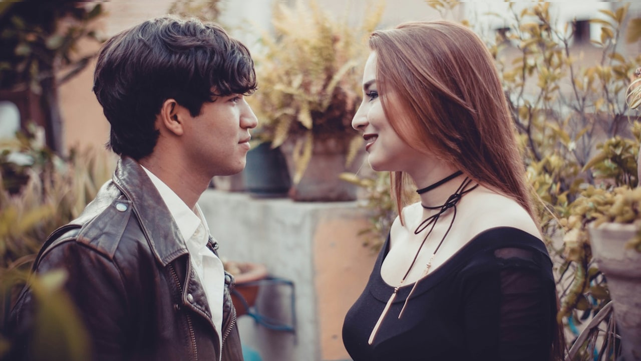 A woman in a black shirt is standing beside a man in a gray button-up shirt.