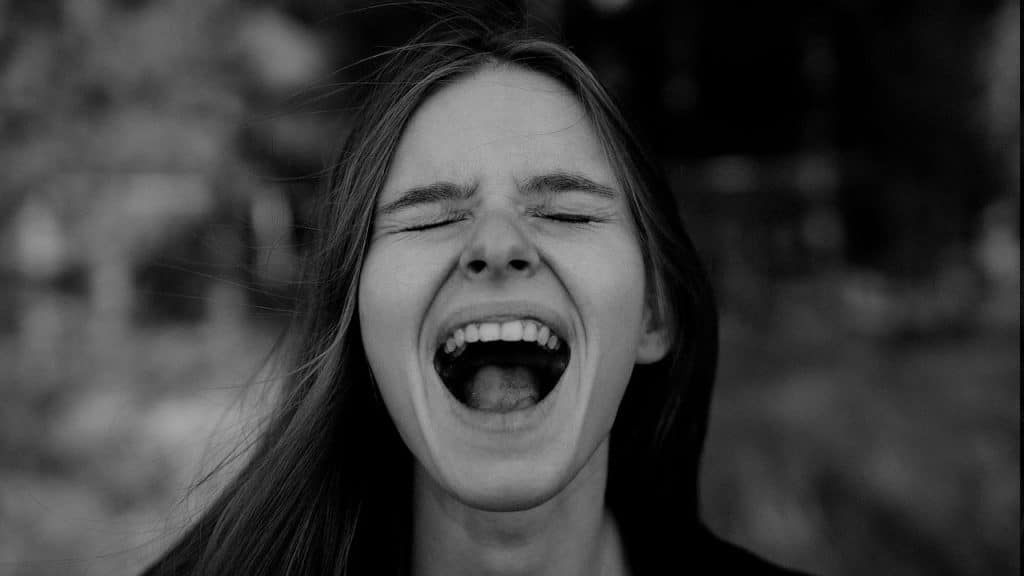 A woman with her eyes closed and mouth wide open.