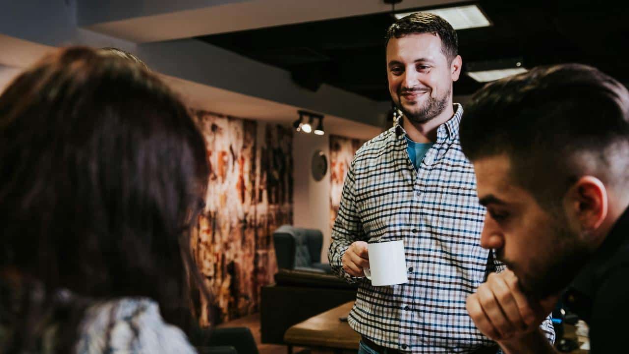 A man holding a mug and smiling
