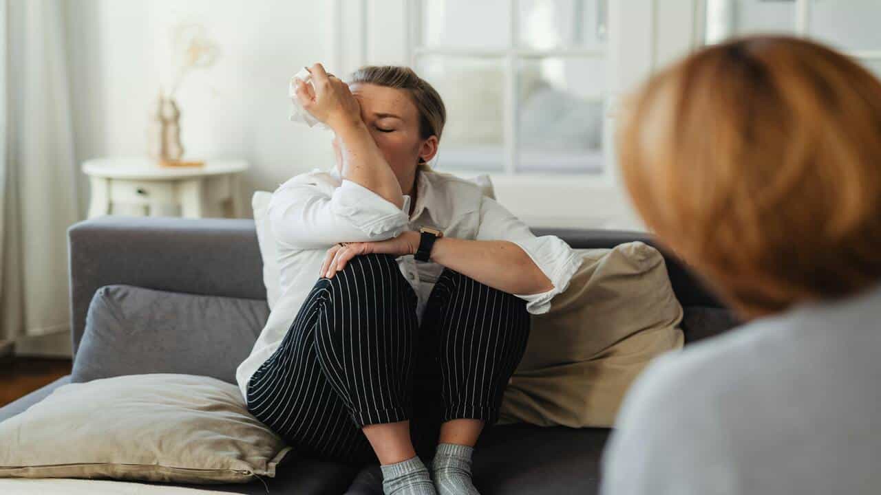 A woman crying to her therapist