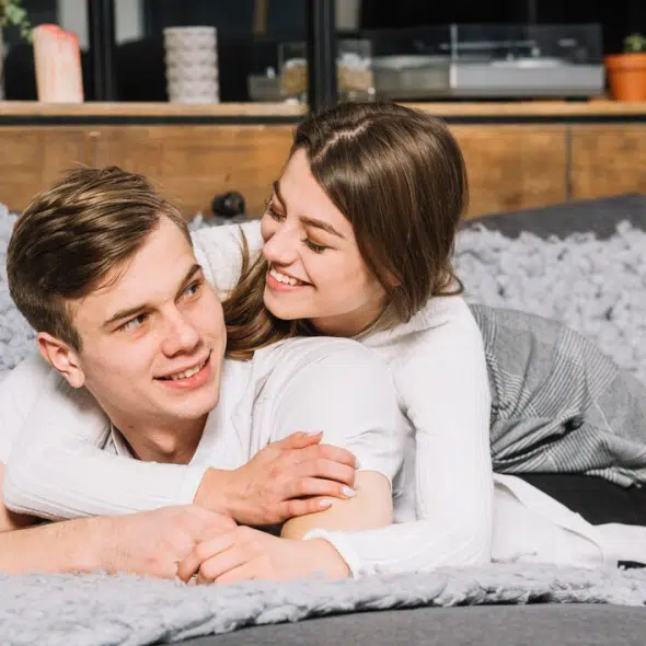 Young couple in white lying on couch