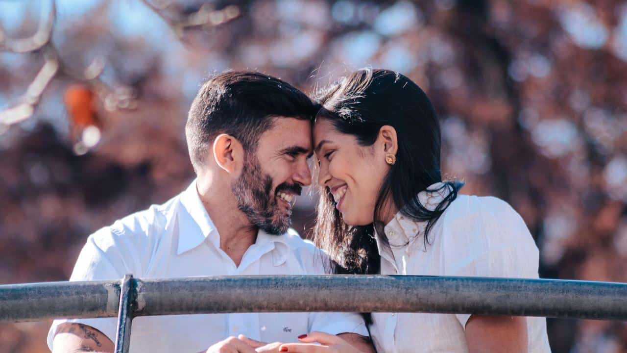 A smiling couple leaning their foreheads together