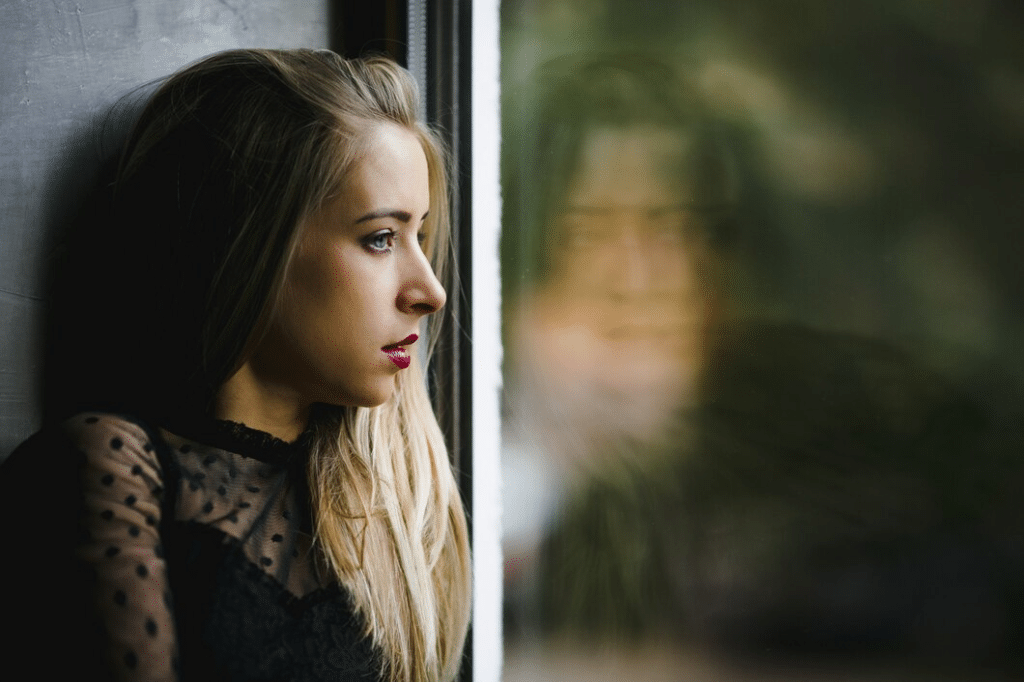 Lonely woman staring outside the window