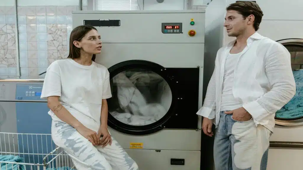 A couple talking while doing the laundry