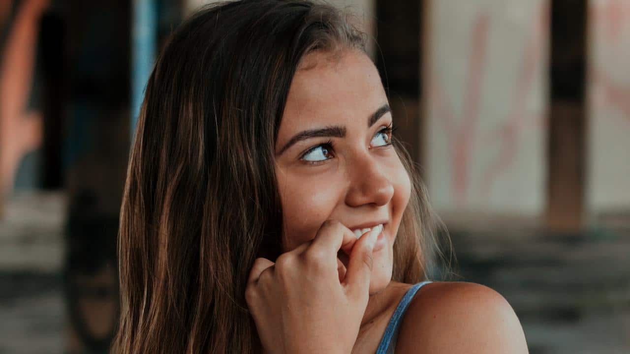 A woman smiling while looking off to the side.