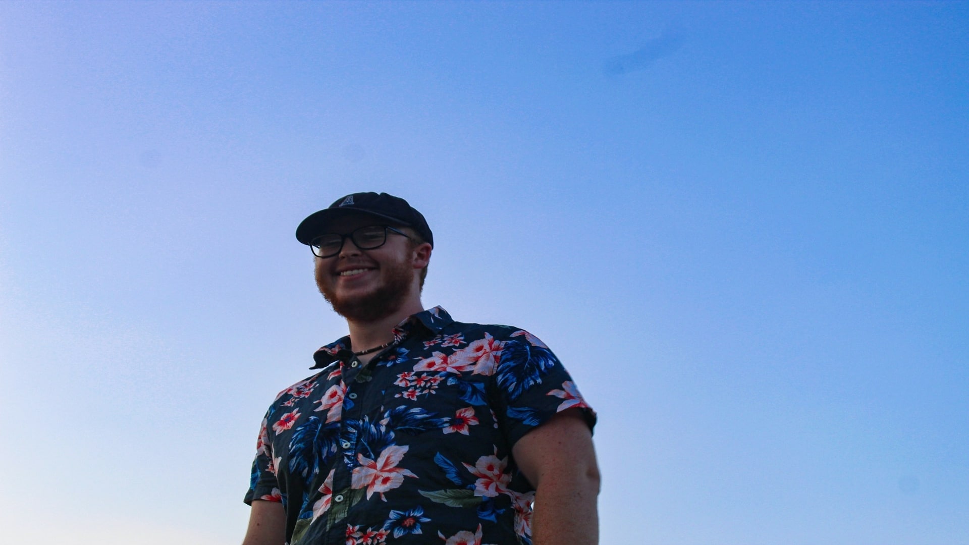 man smiling while walking outdoors
