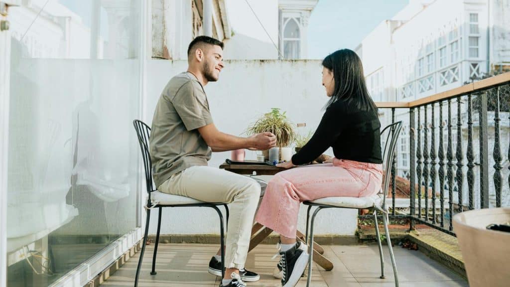 A couple sitting at a small balcony table