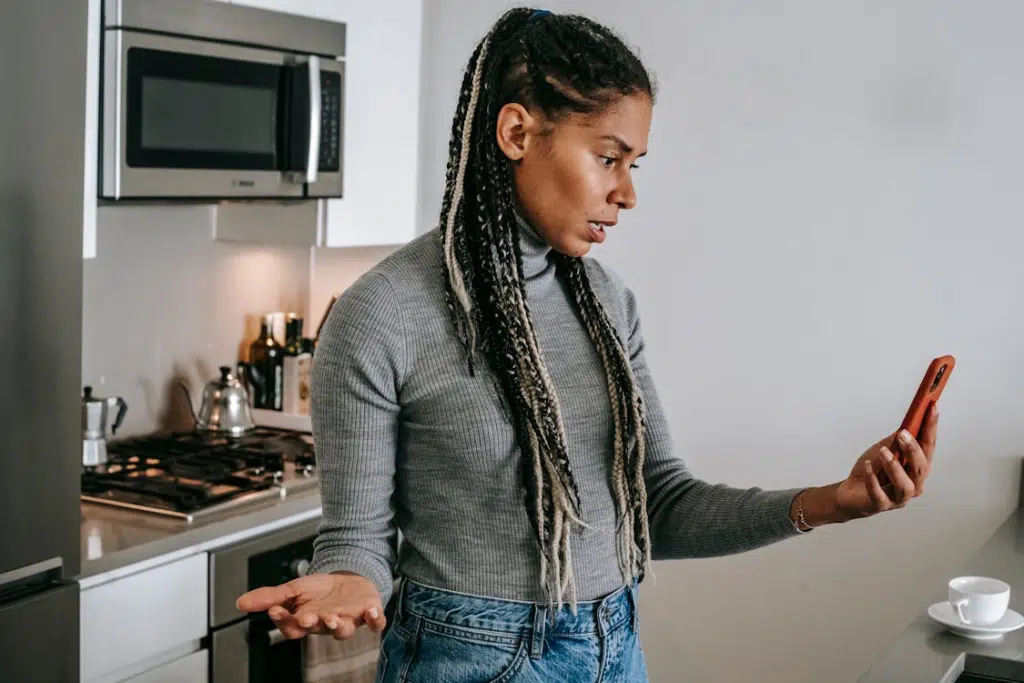 Confused female having video conversation on mobile phone at home