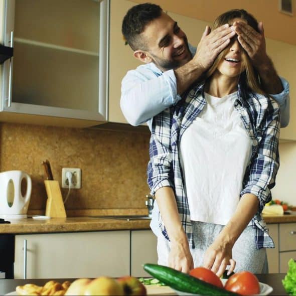 A man covering woman’s eyes