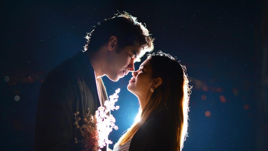 A man and woman kissing during nighttime.