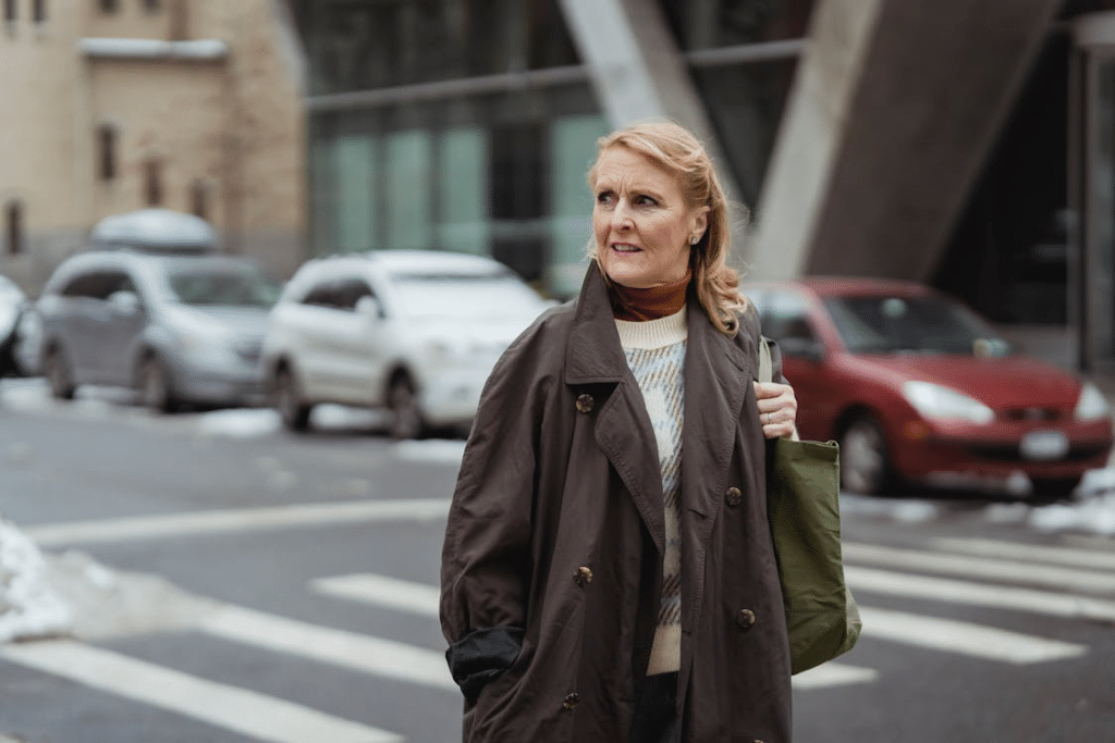 Single woman 40s looking thoughtful in city street