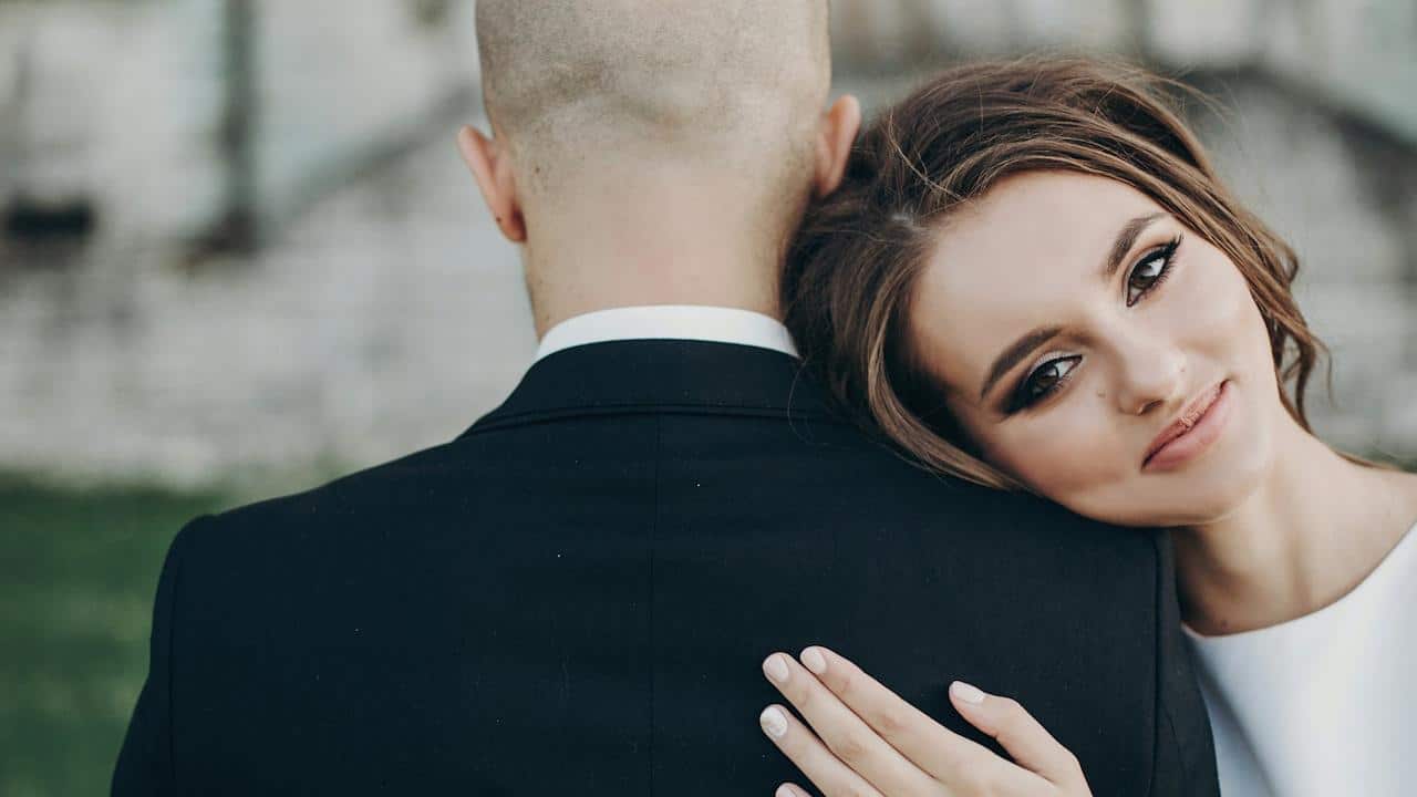 A woman leaning her head on a man's shoulder.