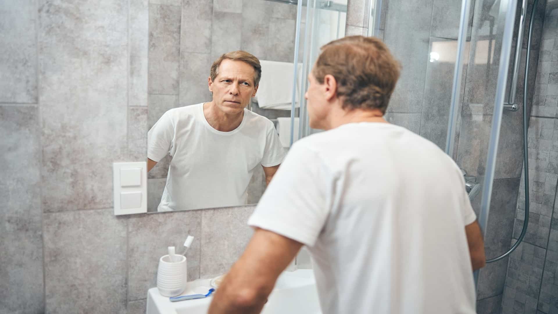 man looking thoughtful in mirror