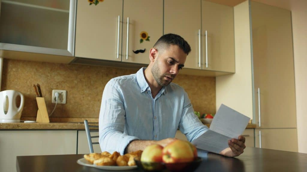 A man looking stressed about the bills