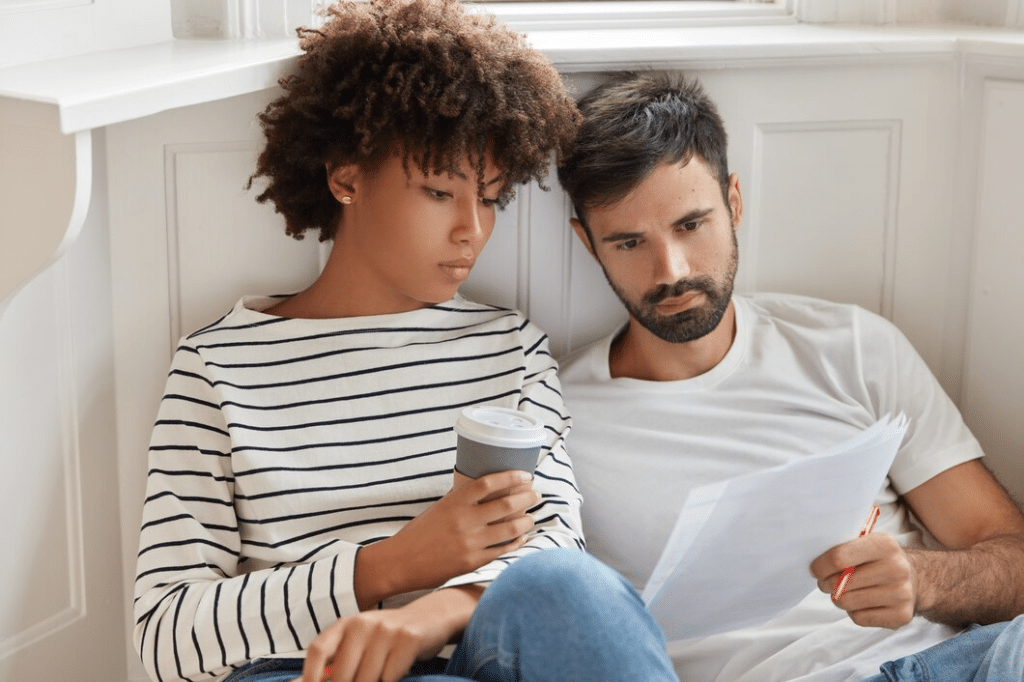 Young couple sitting and looking at papers