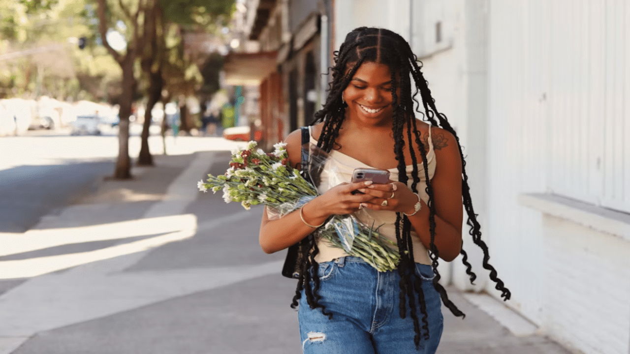 A woman smiling at her phone