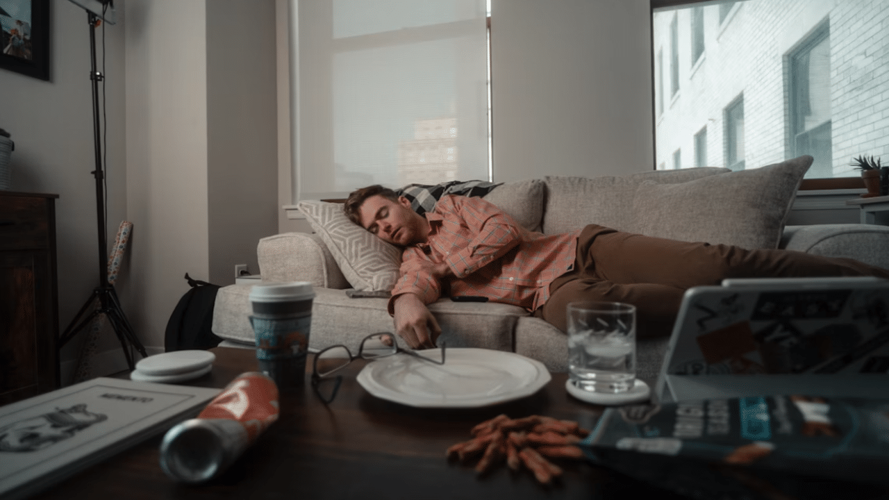 A man sleeping on the couch instead of working