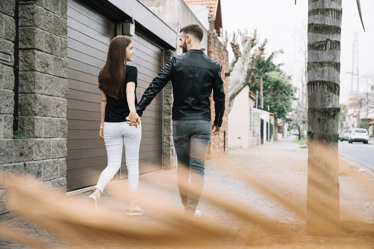 A man and woman holding hands while walking