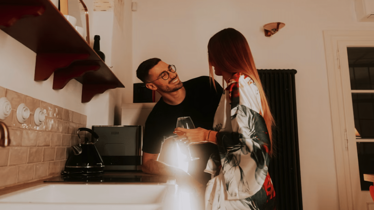 A couple laughing in the kitchen together