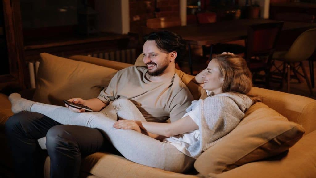 A couple smiling while watching TV