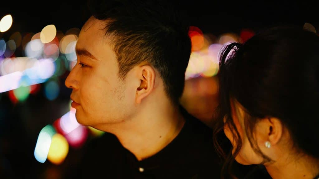 A man looking to the side as a woman stares at him.