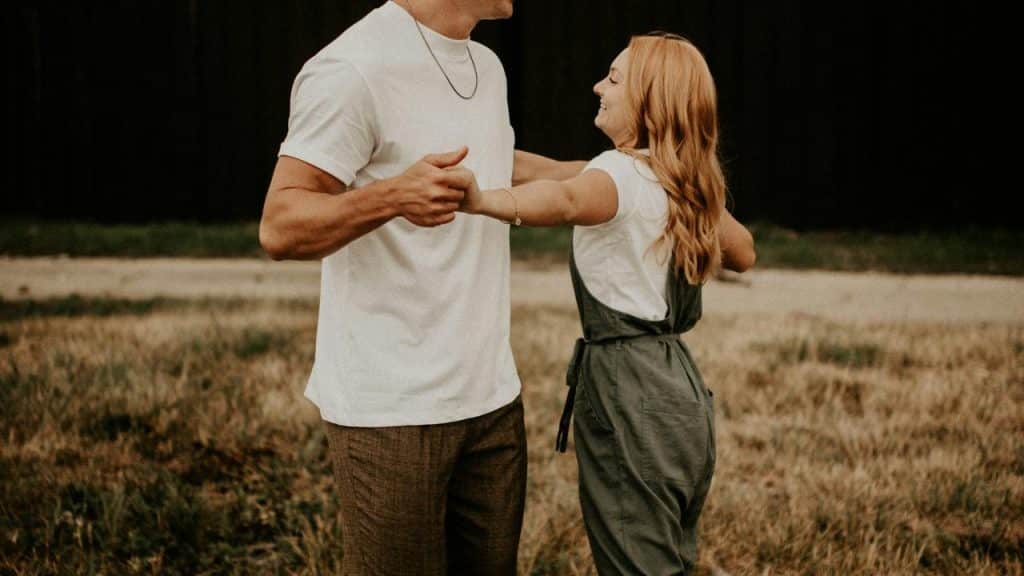 A couple dancing together in an open field.