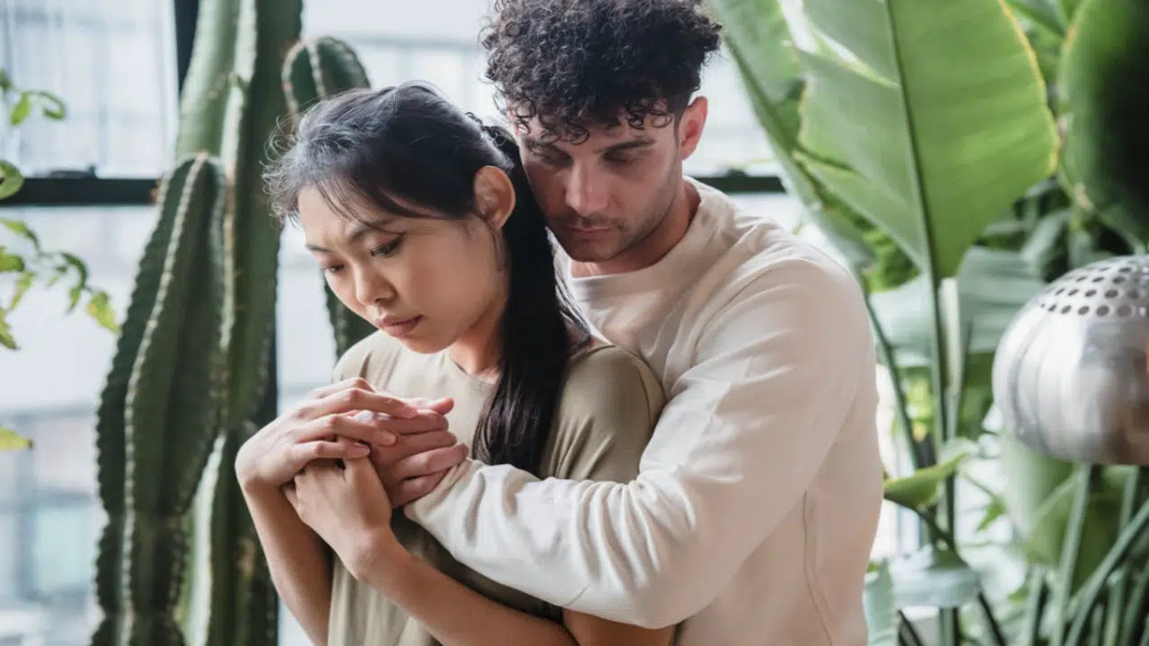 A couple hugging by the window
