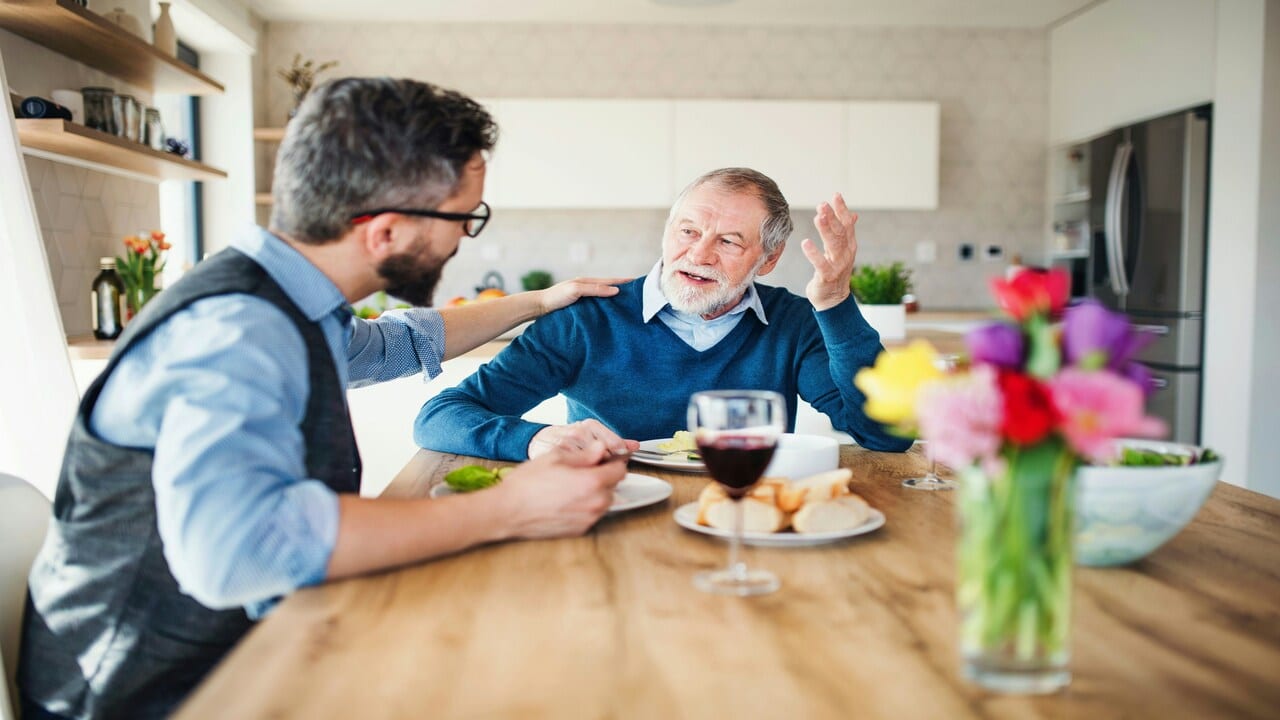 A father and an adult son having a meal at home