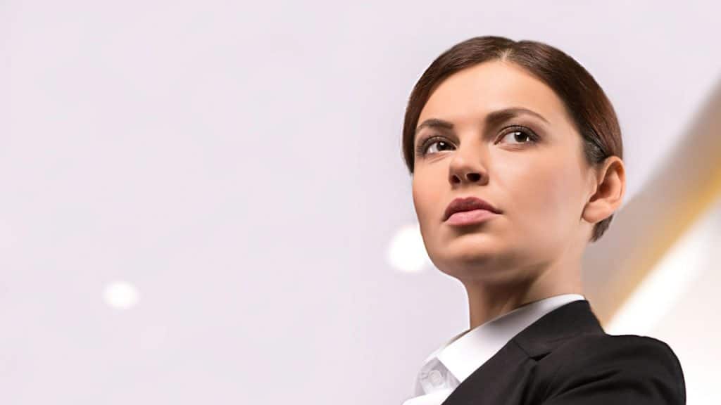 A woman looking to the side with a serious expression.
