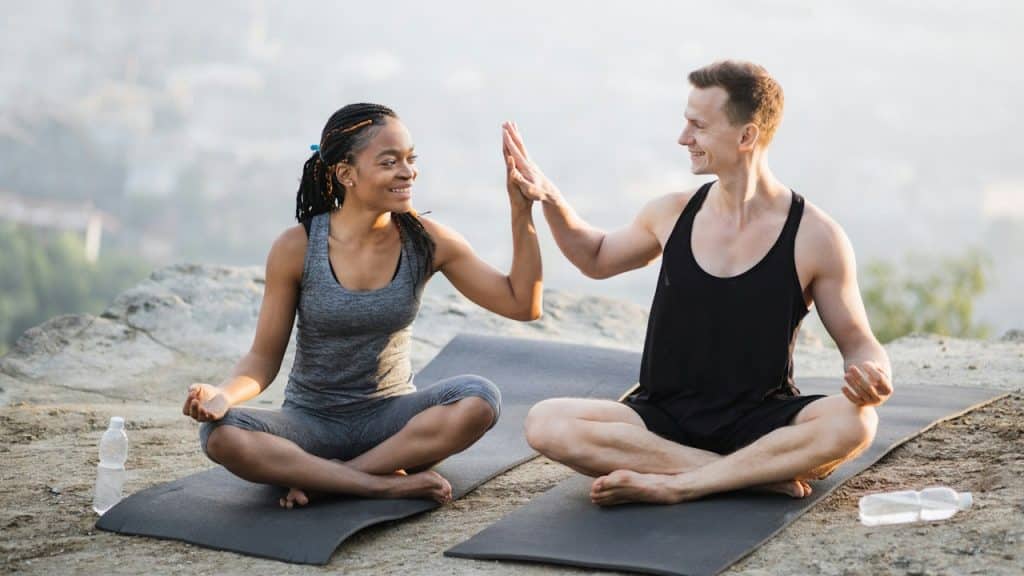 Caucasian man and African woman enjoying outdoor training together.