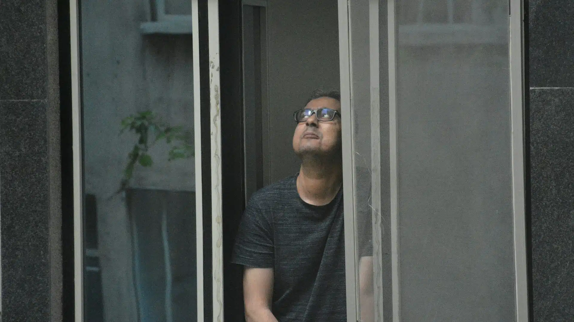 man looking thoughtful by window