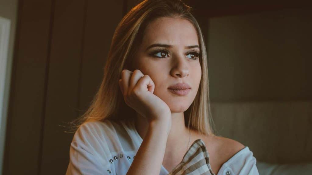 A woman resting her chin on her hand while looking away.