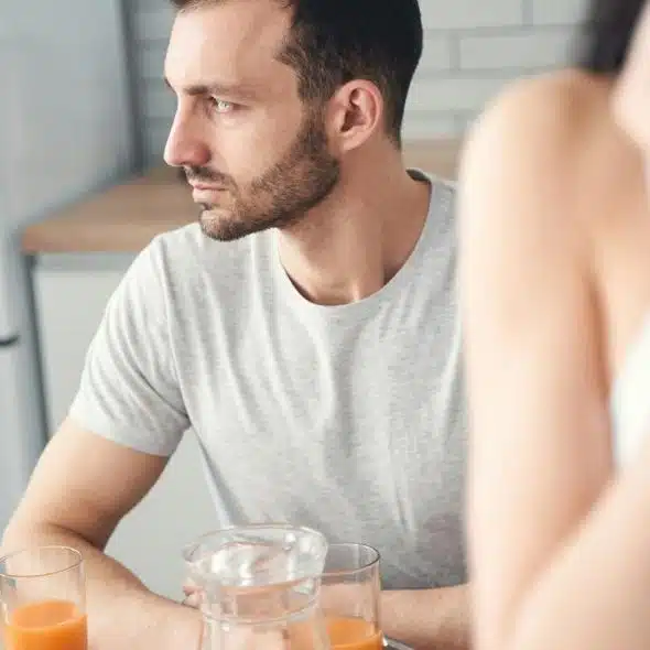 A serious man sits at a table