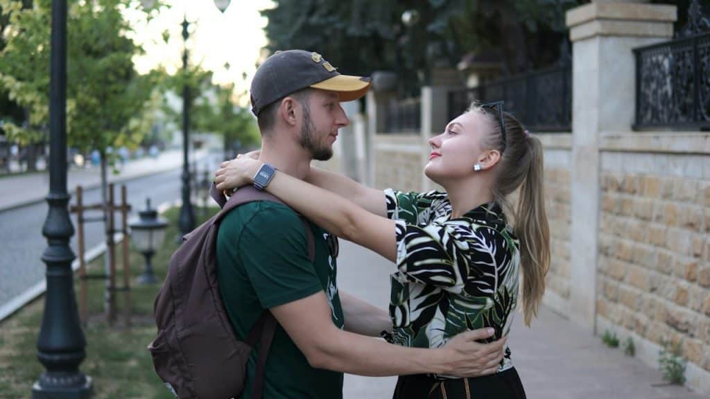 A man standing next to a woman on a sidewalk.